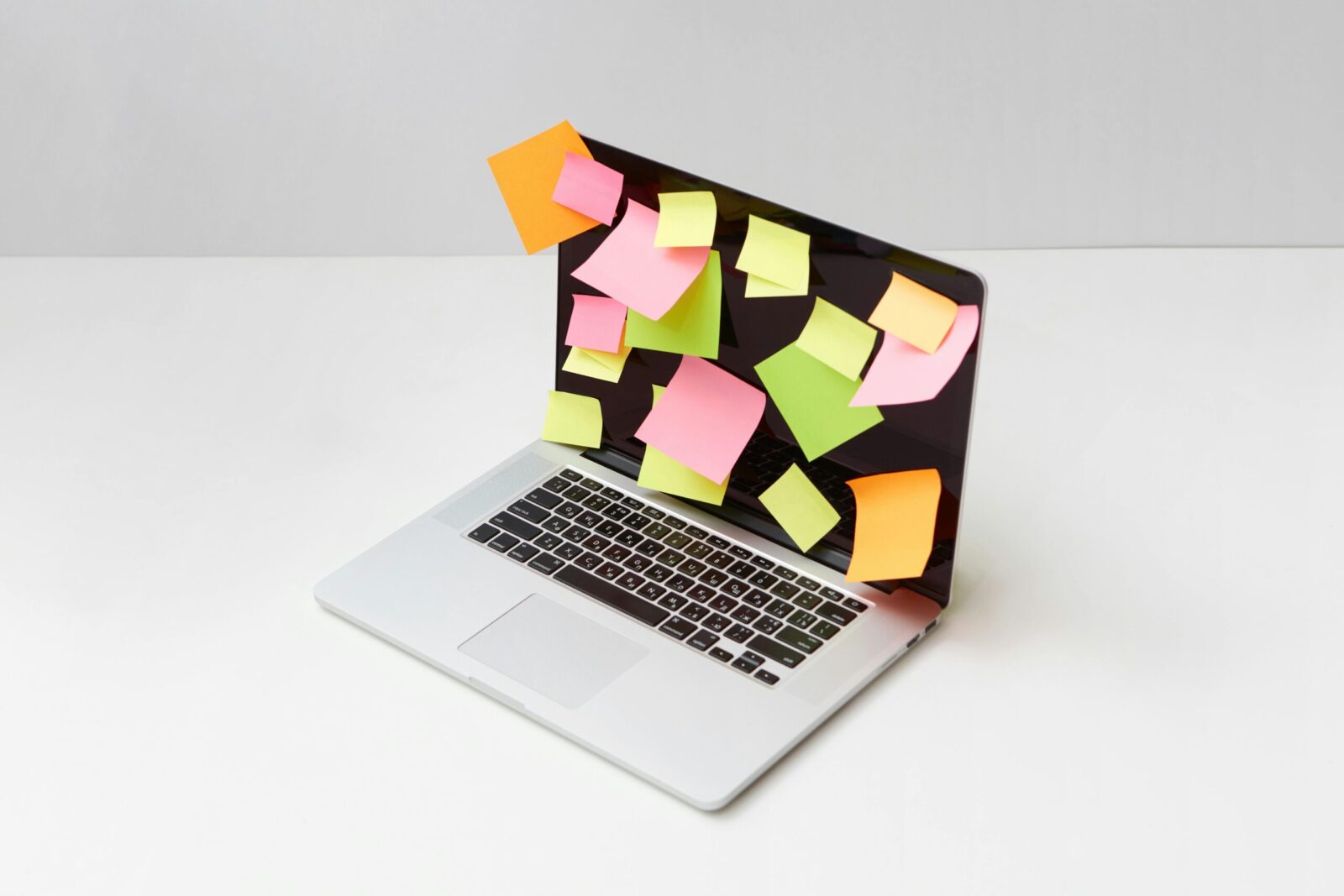 Laptop screen covered with colorful sticky notes for organization and ideas.